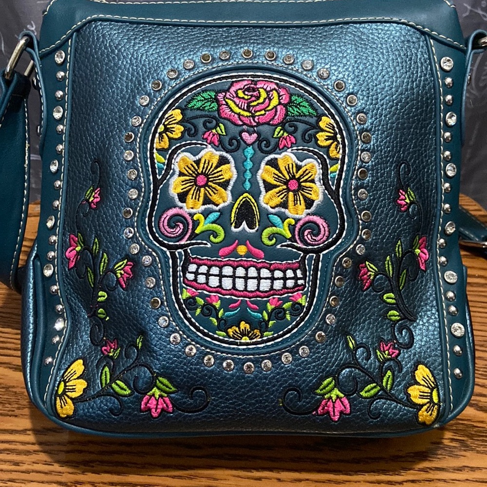 Metallic blue/green Montana West sugar skull crossbody conceal and carry bag.